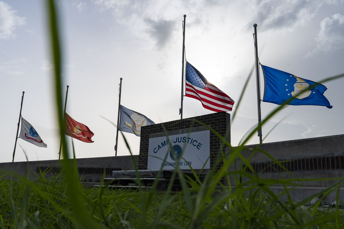 In this photo reviewed by U.S. military officials, flags fly at half-staff in honor of the U.S. service members and other victims killed in the terrorist attack in Kabul, Afghanistan, at Camp Justice, Sunday, Aug. 29, 2021, in Guantanamo Bay Naval Base, Cuba. Camp Justice is where the military commission proceedings are held for detainees charged with war crimes.  (Alex Brandon)