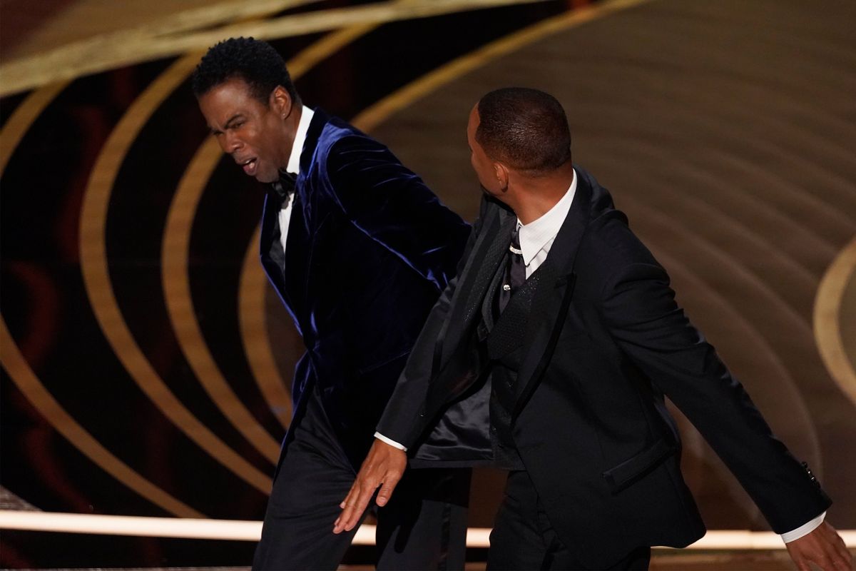 Will Smith, right, hits presenter Chris Rock on stage while presenting the award for best documentary feature at the Oscars on Sunday, March 27, 2022, at the Dolby Theatre in Los Angeles.  (Chris Pizzello)