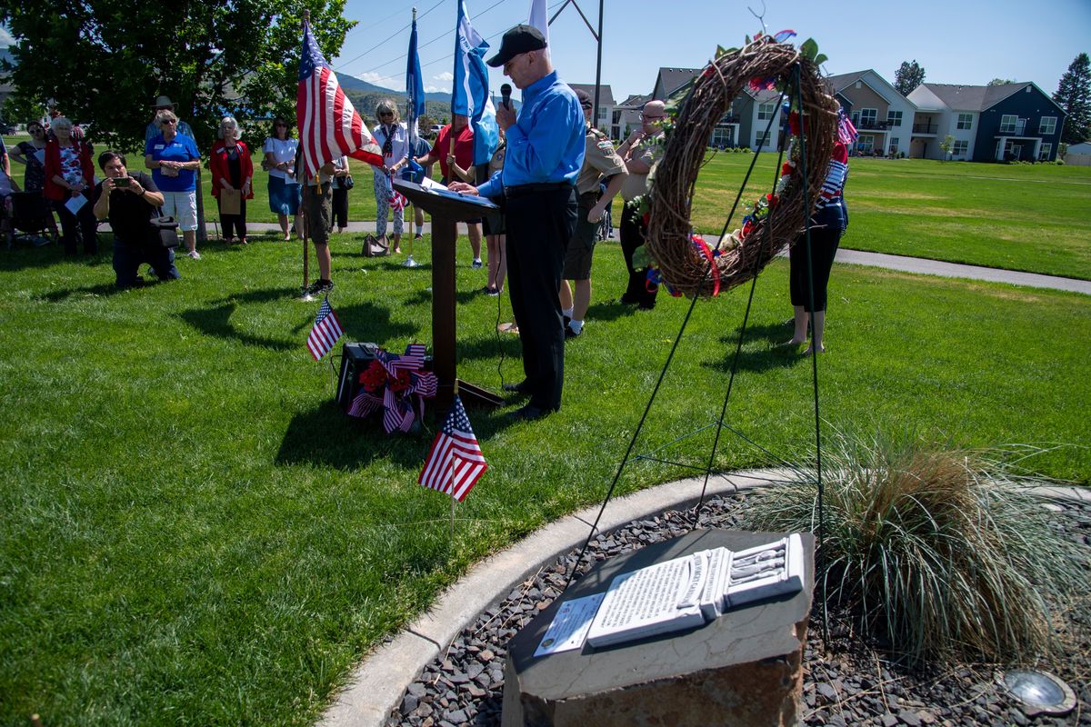 Craig Fallon, retired from the elite military unit that guards the Tomb of the Unknown Soldier at Arlington National Cemetery, says a few words over the small plaque laid in a “Never Forget” garden in Orchard Park in Liberty Lake, unveiled Monday.  (Jesse Tinsley/THE SPOKESMAN-REVIEW)