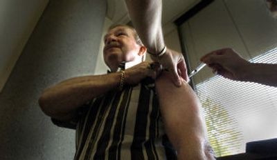 
Gary Myhro gets his flu shot at the Spokane County Health District on Friday morning. High-risk people can make an appointment to get their shots during clinic business hours. 
 (Christopher Anderson/ / The Spokesman-Review)