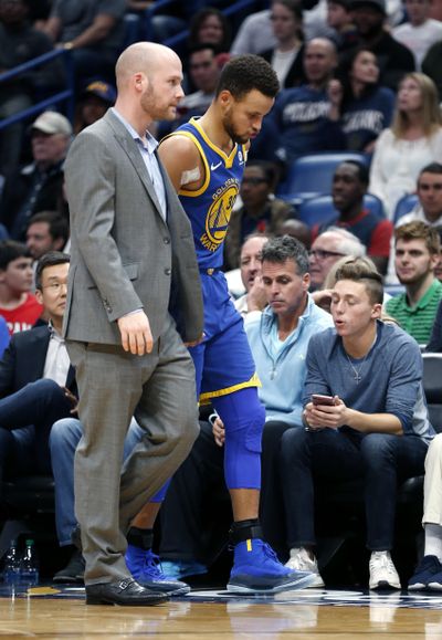 Golden State Warriors guard Stephen Curry, right, limps off the court to the locker room in the second half of an NBA basketball game against the New Orleans Pelicans in New Orleans, Monday, Dec. 4, 2017. (Gerald Herbert / Associated Press)