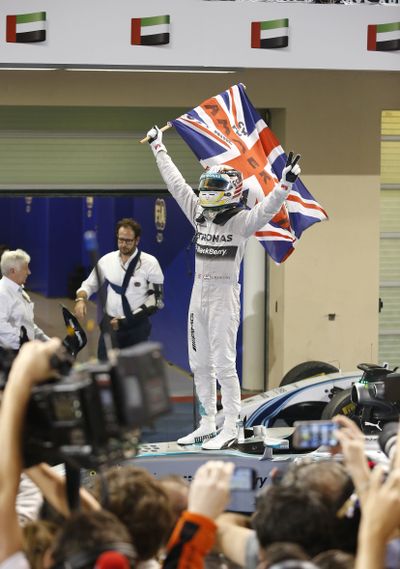 Mercedes driver Lewis Hamilton celebrates after winning the Abu Dhabi Grand Prix and his second Formula One world championship. (Associated Press)