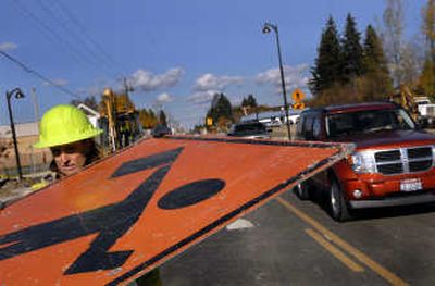 
Audrey Wadsworth,  of Eclipse Traffic Control & Flagging, picks up signs Thursday on  Government Way before the road's reopening. 
 (Kathy Plonka / The Spokesman-Review)