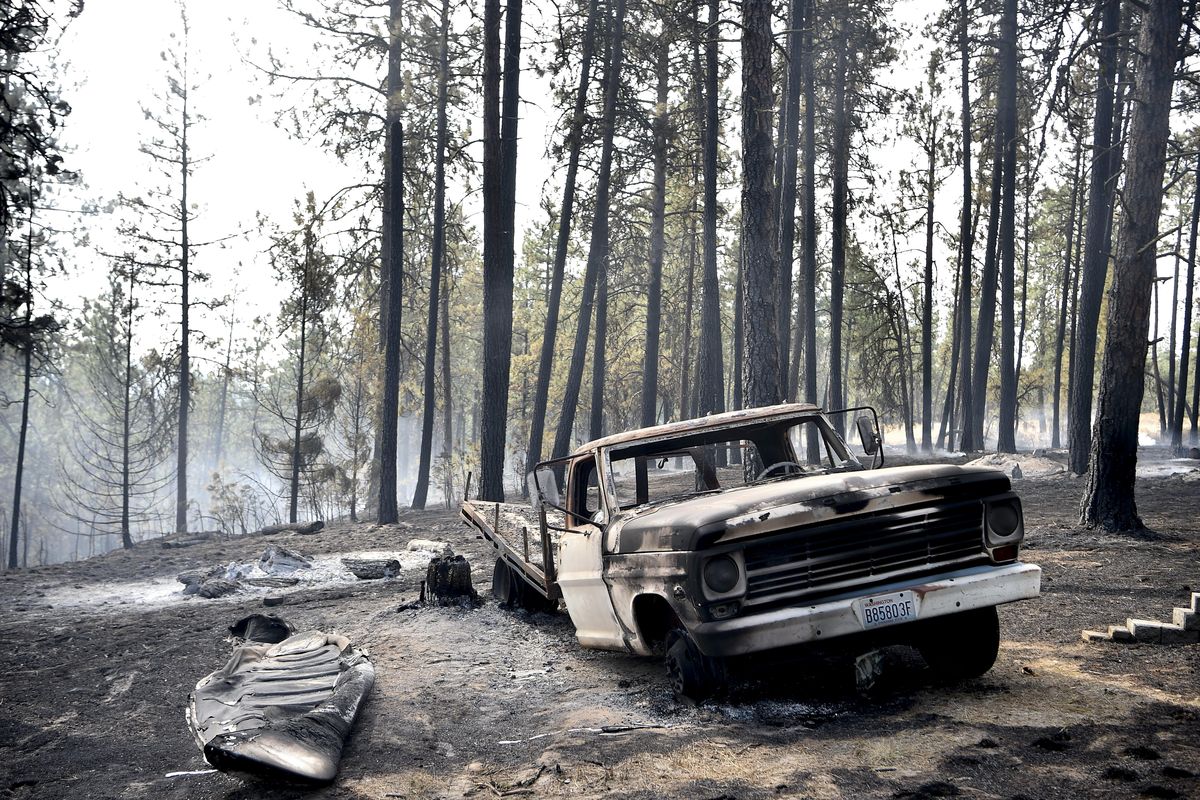 A charred truck is seen near Julie Thayer and her husband Art