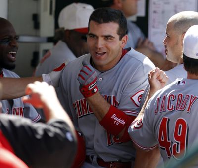 Cincinnati’s Joey Votto is mobbed in the dugout by his teammates after hitting one of his N.L.-leading 21 homers. (Associated Press)
