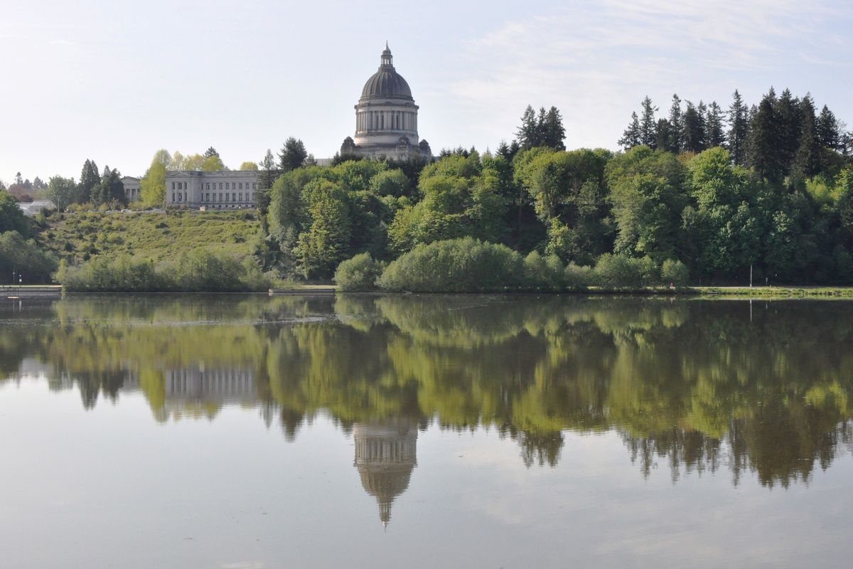 Washington’s domed Legislative Building, completed in 1928, and the nearby Temple of Justice, reflected in Capitol Lake on a calm day.  (By Jim Camden / For The Spokesman-Review)