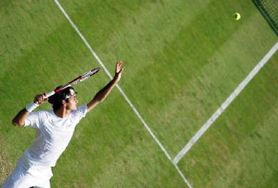 
Defending champion Roger Federer serves to France's Nicolas Mahut en route to Friday's three-set victory. 
 (Associated Press / The Spokesman-Review)