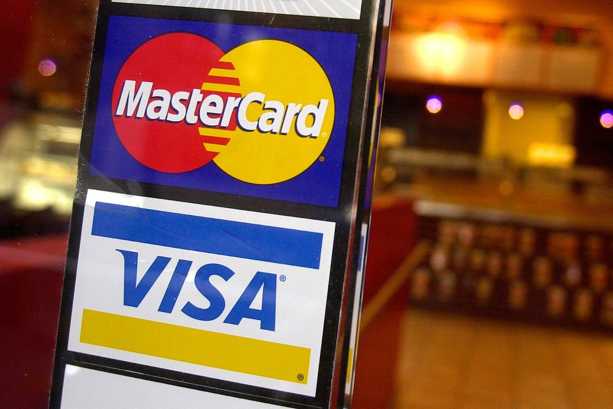 The logos for MasterCard and Visa credit cards are displayed at the entrance of a New York coffee shop on April 22, 2005. Mastercard and Visa have suspended their operations in Russia.  (Associated Press )