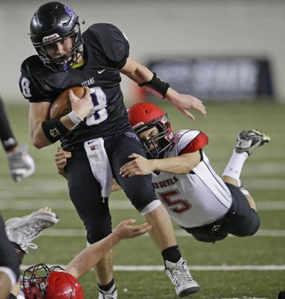 Odessa-Harrington quarterback Colton Hunt, who rushed for 110 yards, is tackled by Neah Bay linebacker Alan Tyler during the second half of the State 1B title game. (Ted S. Warren / Associated Press)