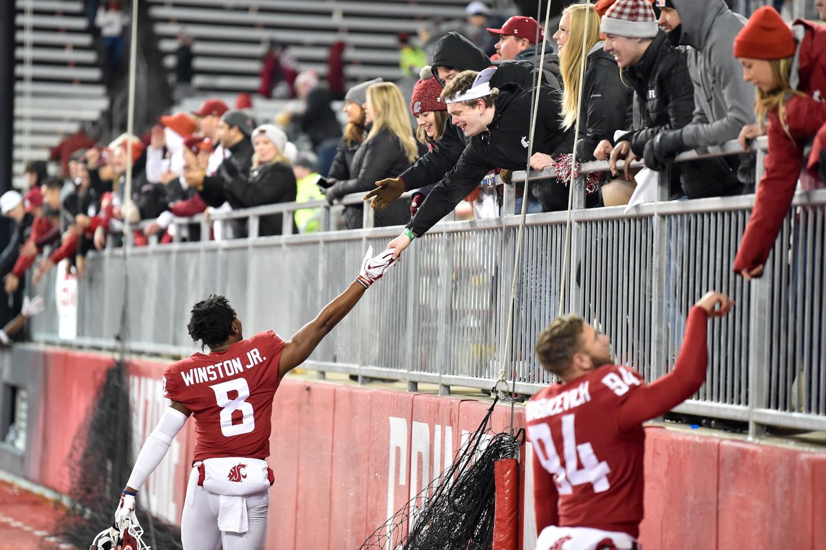 Washington State  wide receiver Easop Winston  and  punter Oscar Draguicevich  celebrate with fans after defeating Arizona  on Nov. 18 at Martin Stadium in Pullman. (Tyler Tjomsland / The Spokesman-Review)