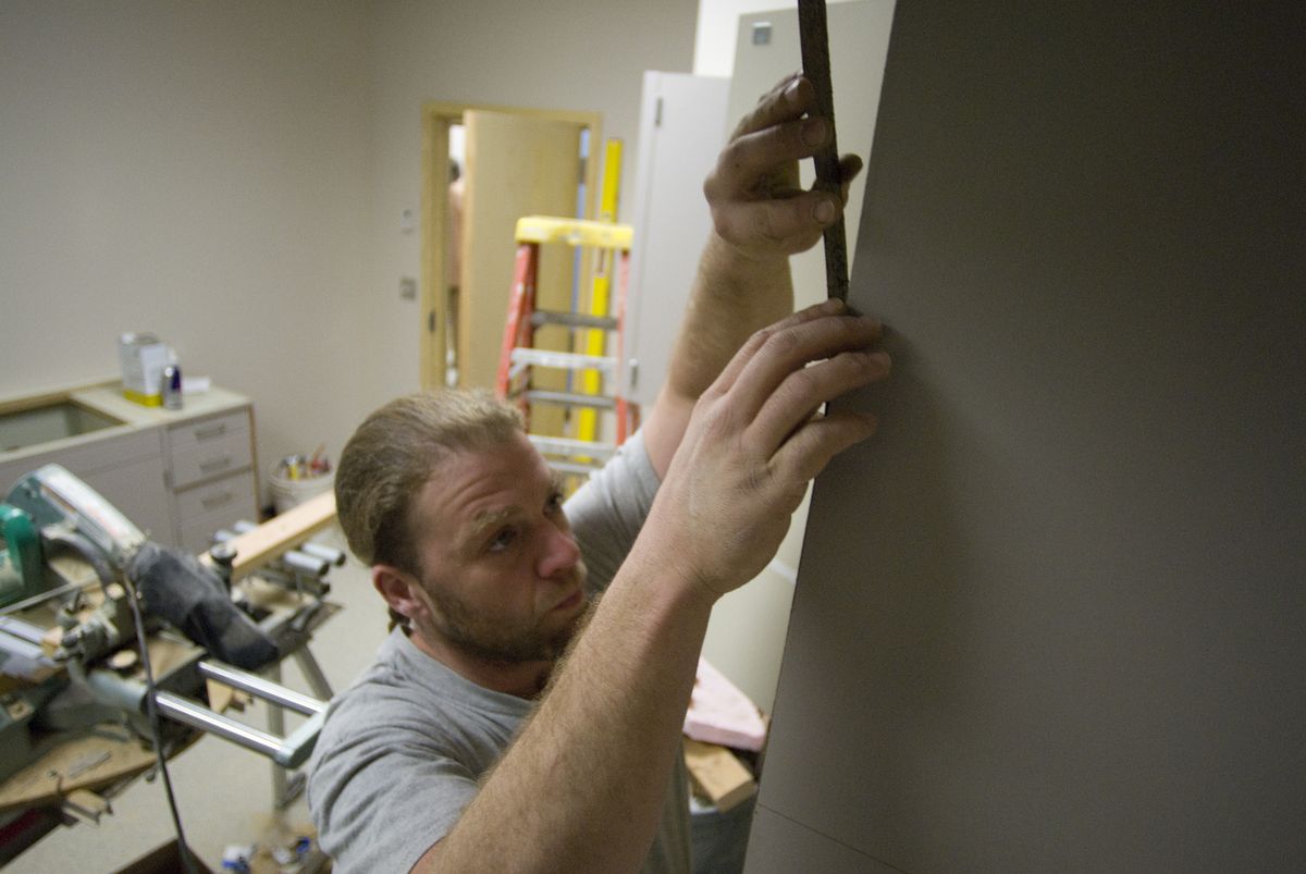 Mike Storer, with Bouten Construction, installs molding on cabinets in the procedure room of the new Christ Clinic at 2410 N. Monroe St. last week. (Colin Mulvany / The Spokesman-Review)