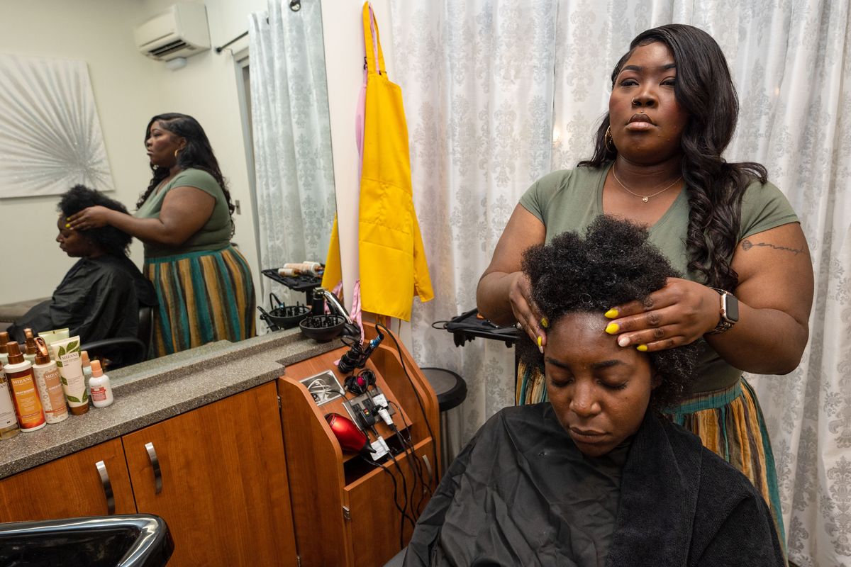 After using leave-in conditioner, hairstylist Kameishi Williams messages scalp conditioner into client Chelsea Messan’s hair. Williams is one of the only Black hairdressers in Spokane. Williams is also a state spokesperson for the Crown Act.  (COLIN MULVANY/THE SPOKESMAN-REVIEW)