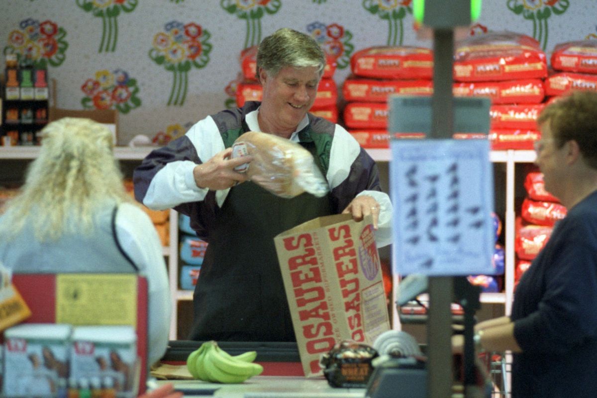 Then-Gonzaga basketball coach Dan Fitzgerald bags groceries at Rosauers on North Francis during a 1995 fundraiser for the American Cancer Society.    (The Spokesman-Review archive)