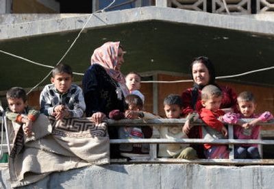 
Iraqi children look at the damage after a car bomber rammed into a U.S. military convoy Thursday in Baghdad, killing one passer-by. 
 (Associated Press / The Spokesman-Review)