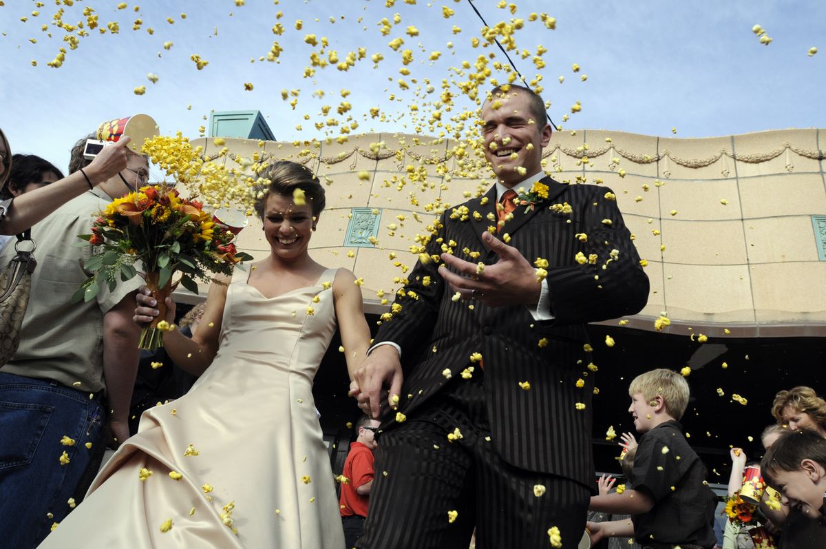 Amy Keppler and Randy Elkins are pelted with popcorn from guests at their wedding Saturday at Garland Theater. The pair dated there many times and decided to tie the knot at the venerable Spokane movie house.  (Jesse Tinsley / The Spokesman-Review)