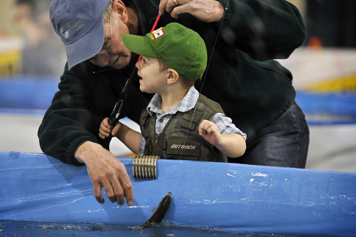 Worth the wait: Owen LeRoy, 2, of Issaquah, Wash., shares with his grandfather Larry Allen, of Post Falls, the boy’s first caught fish Friday at the Big Horn Outdoor Adventure Show at the Spokane County Fair and Expo Center. The rainbow trout fishing area, presented by the Inland Northwest Wildlife Council, offers participants a chance to catch a live fish and to keep it or donate it to the Union Gospel Mission. The pair decided to offer it to the mission. The show runs through Sunday. (Dan Pelle)