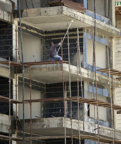 A Palestinian works Thursday on a building in Ashkelon, Israel, whose mayor has suspended Israeli Arab laborers from work at day-care centers. (Associated Press)