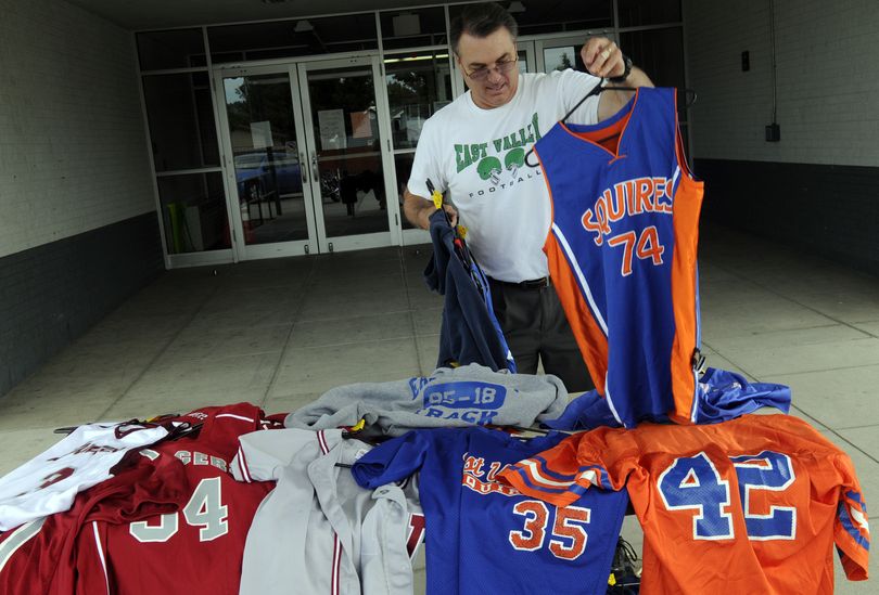 East Valley Athletic Director Joe Kostecka lays out Mountain View Lancer and East Valley Middle School Squires uniforms that will be sold during Friday’s sale. (J. Bart Rayniak)