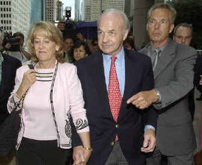 
An unidentified man directs former Enron Corp. chairman and CEO Kenneth Lay and his wife Linda to a waiting car after Lay's appearance in federal court in Houston last month.
 (Associated Press / The Spokesman-Review)