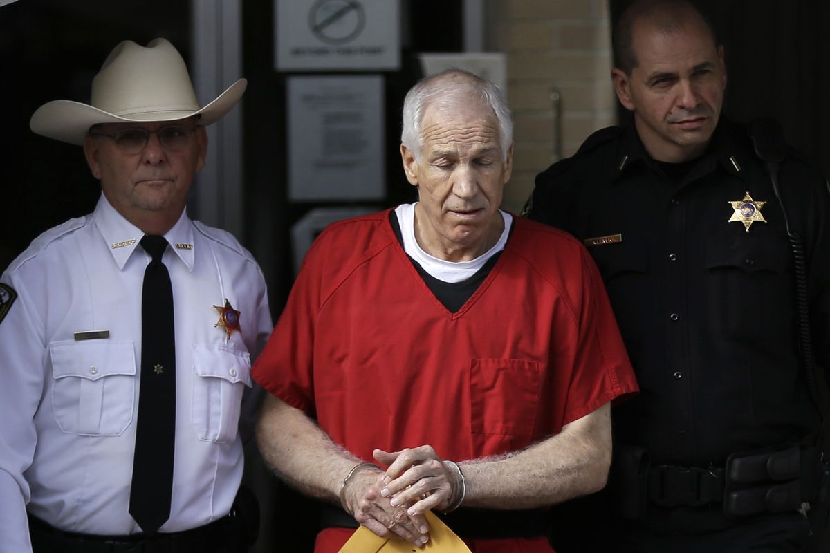 Former Penn State University assistant football coach Jerry Sandusky, center, is taken from the Centre County Courthouse by Centre County Sheriff Denny Nau, left, and a deputy, after being sentenced in Bellefonte, Pa., Tuesday, Oct. 9, 2012. Sandusky was sentenced to at least 30 years in prison, effectively a life sentence, in the child sexual abuse scandal that brought shame to Penn State and led to coach Joe Paterno
