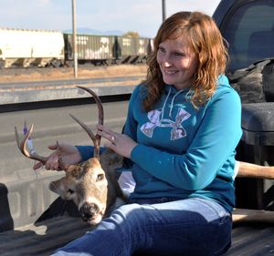 Erin Van Horn of Shelton, Wash., pauses at the Deer Park hunter check station with a whitetail buck she shot in October. “It’s a small buck but it should be delicious,” she said. Women are more likely than men to hunt “for the meat,” a survey found. (Rich Landers)