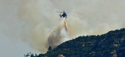 
A skycrane drops water Saturday on a hot spot of the Brins fire in Sedona, Ariz. Officials said the blaze was 20 percent contained, with full containment predicted by Wednesday. 
 (Associated Press / The Spokesman-Review)