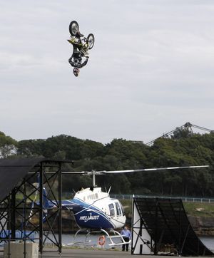 ORG XMIT: XRR104 Daredevil rider Travis Pastrana of the United States jumps his motorcycle over the spinning blades of a helicopter in Sydney, Australia, Wednesday, Oct. 28, 2009. Pastrana is promoting the high octane show set to tour Australia from May, 2010 (AP Photo/Rick Rycroft) (Rick Rycroft / The Spokesman-Review)