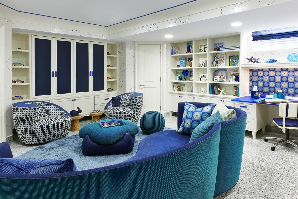 This undated photo provided by Jenny Kirschner shows a basement designed by the New York-based interior designer. Closed storage and ample shelving help keep this basement playroom feeling organized, while layered rugs and soft upholstery add plenty of warmth in this basement. (Ryan Dausch / AP)