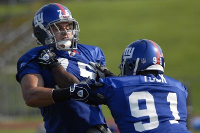 Justin Tuck, right,  battling Alex Morrow during a New York Giants practice, has some big shoes to fill.  (Associated Press / The Spokesman-Review)