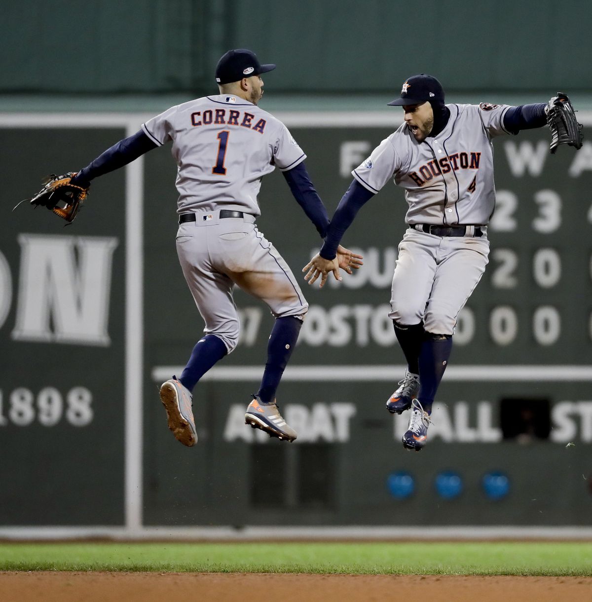 Houston Astros center fielder George Springer, right, and shortstop Carlos Correa celebrate their win against the Boston Red Sox in Game 1 of a baseball American League Championship Series on Saturday, Oct. 13, 2018, in Boston. The Astros won 7-2. (David J. Phillip / Associated Press)