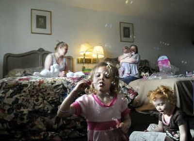 
Jessica Landberg, left, her mother, Marcel Smith, right, and Landberg's children  sit in the motel room Monday where they spent the weekend. Landberg's daughters are Heidi, center, Alana and Kylie, in Smith's arms. The family was caught between homes and found no emergency services to help.
 (CHRISTOPHER ANDERSON / The Spokesman-Review)