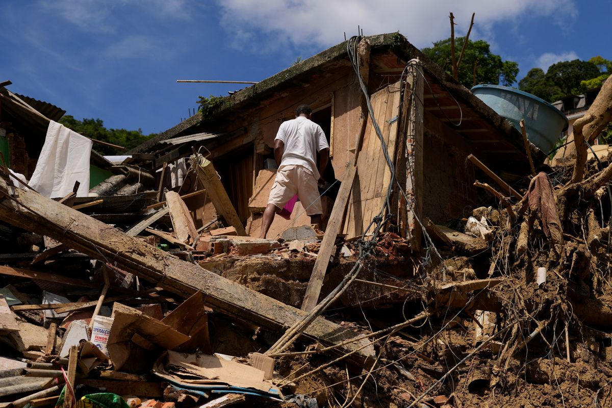 A resident stands on property destroyed by mudslides on the second day of rescue efforts in Petropolis, Brazil, Thursday, Feb. 17, 2022. Deadly floods and mudslides swept away homes and cars, but even as families prepared to bury their dead, it was unclear how many bodies remained trapped in the mud. (Silvia Izquierdo)