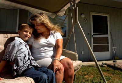 
Kim Carlson sits in her front yard in Spirit Lake with her son, Daniel Davis, 10, on Tuesday. They moved into their first home April 14 with help from an  Idaho Housing and Finance Association program. Buying the home was a goal she had worked toward since 1999.
 (Photos by KATHY PLONKA / The Spokesman-Review)