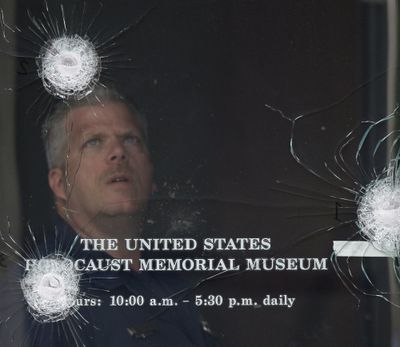 ORG XMIT: DCAB110 Washington police investigator George Klein Jr. examines bullet strikes in one of the doors of the U.S. Holocaust Memorial Museum in Washington, Thursday, June 11, 2009, a day after a shooting left a security officer dead and the gunman wounded. (AP Photo/Alex Brandon) (Alex Brandon / The Spokesman-Review)
