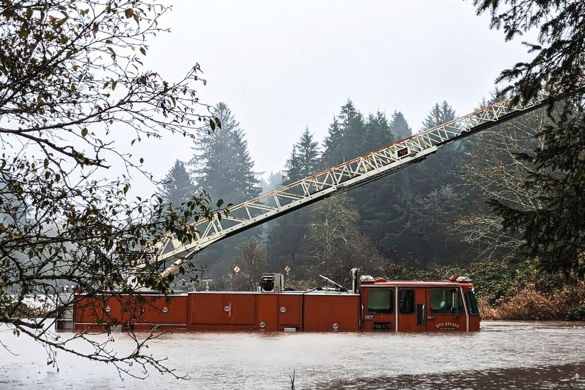 A fire engine is surrounded by rising waters Friday in Otis, Ore. The U.S. Coast Guard used two helicopters to rescue about 50 people from rising waters at an RV park on the Oregon Coast as heavy rains in the Pacific Northwest prompted warnings of floods and landslides.  (Jack Dunteman)