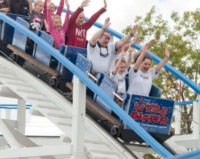 this photo taken by AP Images for Spark Energy, U.S. Army Staff Sgt. (Ret.) Dan Shannon and his family ride the Little Dipper rollercoaster at Six Flags Great America during the Spark Energy Helping A Hero event in Gurnee, Il., Saturday, September 17, 2011. (Peter Barreras / Associated Press)