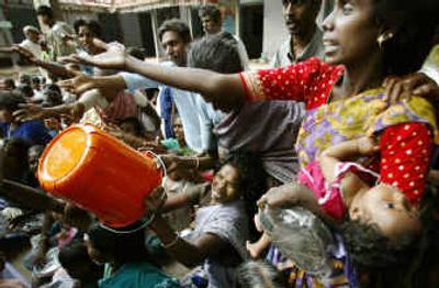 
Homeless people receive aid on Thursday at a temporary shelter in Parangipet, in the southern Indian state of Tamil Nadu, where several thousand have died and many more have been displaced. 
 (Associated Press / The Spokesman-Review)