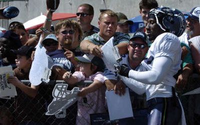 
Seattle Seahawks cornerback Marcus Trufant tries to keep up with the demand for his autograph after morning training camp practice in Cheney
 (Dan Pelle / The Spokesman-Review)