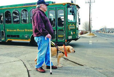
George Davis and his service dog, Gomer, wait at Boone and Howard on Friday. 