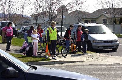 
Crossing guard Karen Droppers waits with Liberty Lake Elementary students Wednesday at the intersection of Molter Road and Mission Road in Liberty Lake. 
 (Liz Kishimoto / The Spokesman-Review)