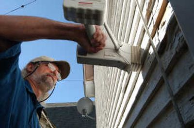 
Bruce Ainslie of MCS Environmental tests the amount of lead  in the exterior paint of a North Spokane home earlier this month. 
 (KATE CLARK / The Spokesman-Review)