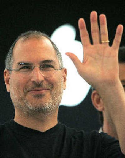 Apple Computer Inc. CEO Steve Jobs waves to reporters after a press conference as he opens the Apple Expo in Paris on Tuesday. Jobs acknowledged that some record companies were pushing him to raise the price of each song download, currently 99 cents on the U.S. ITunes site.
 (Associated Press / The Spokesman-Review)