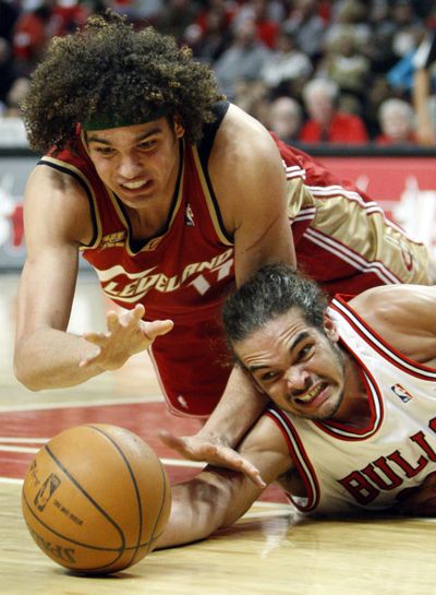 Cleveland’s Anderson Varejao, top, and Chicago’s Joakim Noah battle for a loose ball during the Bulls’ 109-108 victory. (Associated Press)