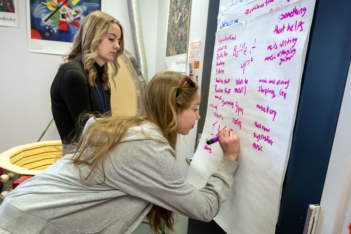 Wilbur Creston High School students Faith Bowden, 17, in back, and Ashleigh Knauer, 16, write down coping skills they can use when feeling sad or depressed during a class empathy building exercise Monday. The school held a Wellness Day for students.  (COLIN MULVANY/THE SPOKESMAN-REVIEW)