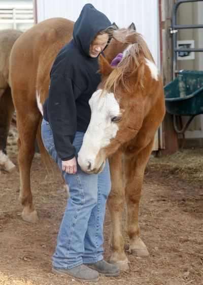 Cheri White Owl, founder of Horse Feathers Equine Rescue, is pictured with one of the 33 horses she is currently caring for, in Guthrie, Okla., Tuesday. Slaughterhouses could be ready to kill horses within a month if the U.S. Department of Agriculture provides funding for meat inspectors, days after Congress quietly opened the door to the practice by lifting a 5-year-old ban on spending federal money on such inspections. (AP/Sue Ogrocki)