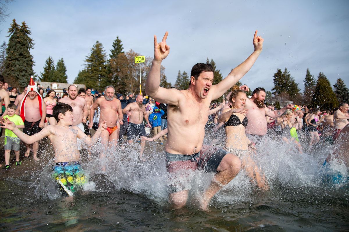 Polar bear plunge participants splash their way into the new year on Sanders Beach in Coeur d