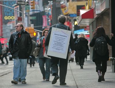 Paul Nawrocki, from Beacon, N.Y., wears a sign as he walks through Times Square seeking employment in New York earlier this month. The government says new claims for unemployment benefits jumped last week to a 16-year high, providing more evidence of a rapidly weakening labor market. (File Associated Press / The Spokesman-Review)