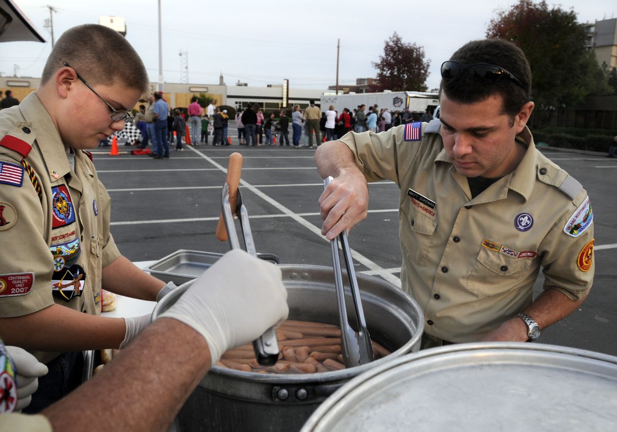 Eagle Scout Tanner Goodhue, left, and Matt Dukeman, development director for the Inland Empire Council, prepare hot dogs for visitors during the Cub Scout kick-off event, the Race to Cub Scouting Rally, Friday. (Jesse Tinsley / The Spokesman-Review)