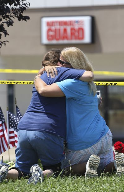 Betty Maynard, left, and Cindy Atterton embrace at a makeshift memorial on Friday in front of the Armed Forces Career Center in Chattanooga, Tenn. (Associated Press)