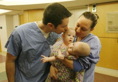 
Jesse Carlsen gives one of his conjoined twin daughters a kiss as he and his wife, Amy, of Fargo, N.D., wait to enter surgery Friday at the Mayo Clinic in Rochester, Minn. 
 (Associated Press / The Spokesman-Review)